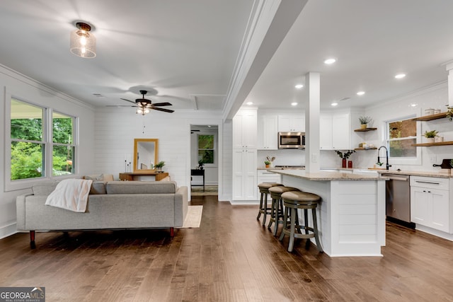 living room with ceiling fan, dark hardwood / wood-style flooring, and ornamental molding