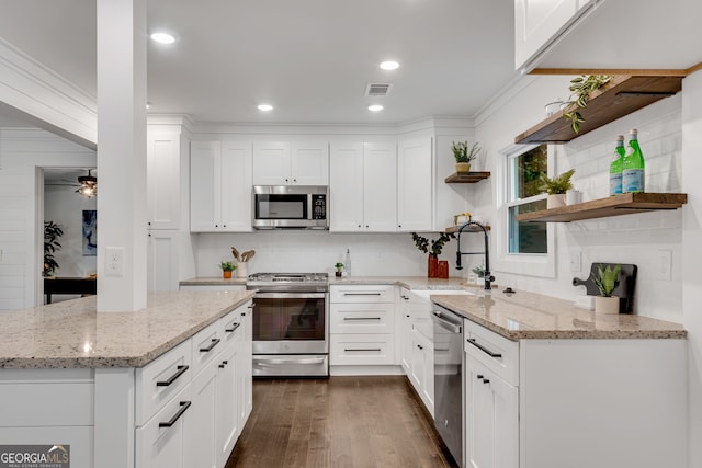 kitchen with white cabinets, light stone counters, sink, and appliances with stainless steel finishes