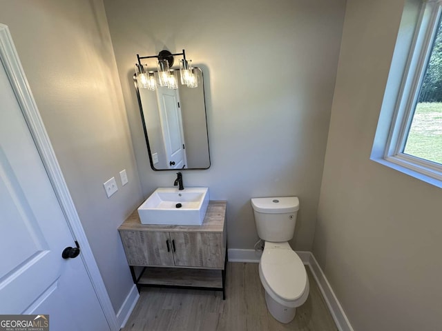 bathroom with hardwood / wood-style floors, toilet, and vanity