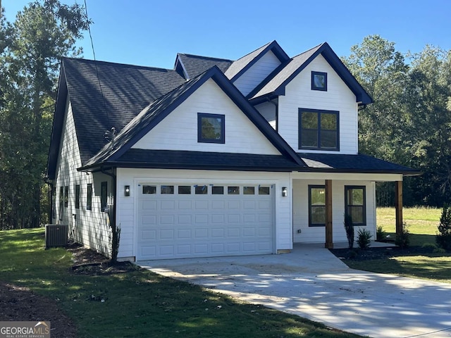 view of front of house with a front lawn, central AC, and a garage