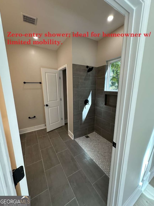 bathroom with tile patterned floors and tiled shower