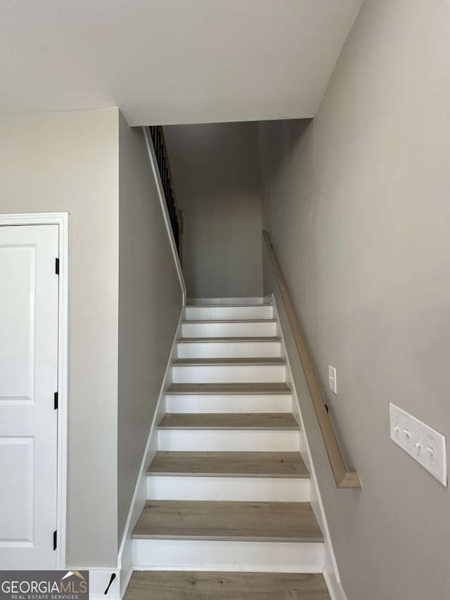 staircase with hardwood / wood-style floors