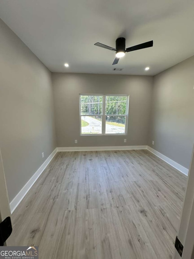 spare room featuring ceiling fan and light hardwood / wood-style flooring