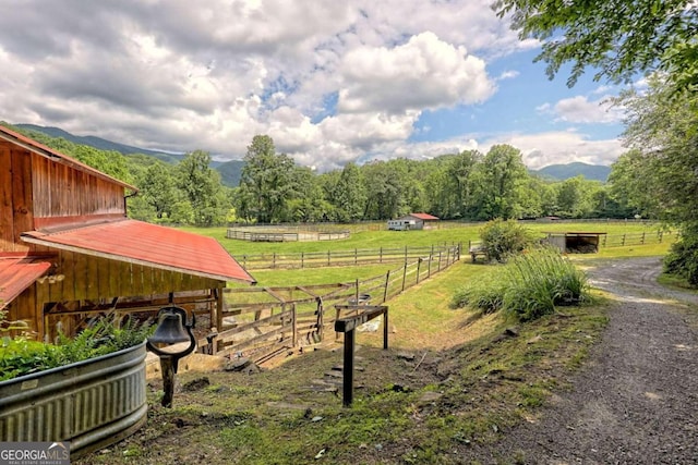 view of home's community with a mountain view, a rural view, and an outbuilding