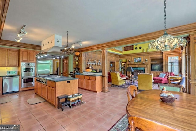 kitchen with ornate columns, range hood, pendant lighting, light tile patterned flooring, and appliances with stainless steel finishes