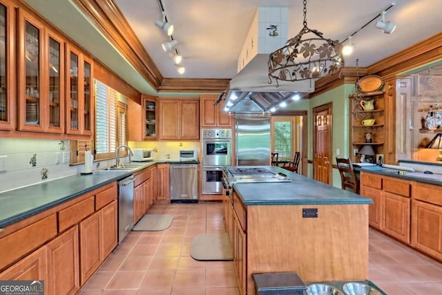 kitchen featuring appliances with stainless steel finishes, crown molding, sink, a kitchen island, and hanging light fixtures