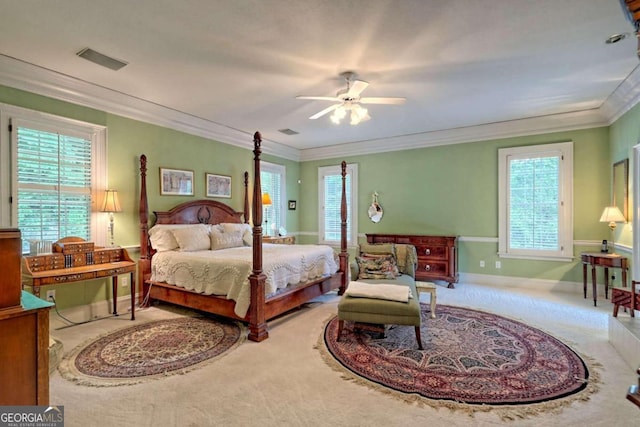 carpeted bedroom featuring ceiling fan, ornamental molding, and multiple windows