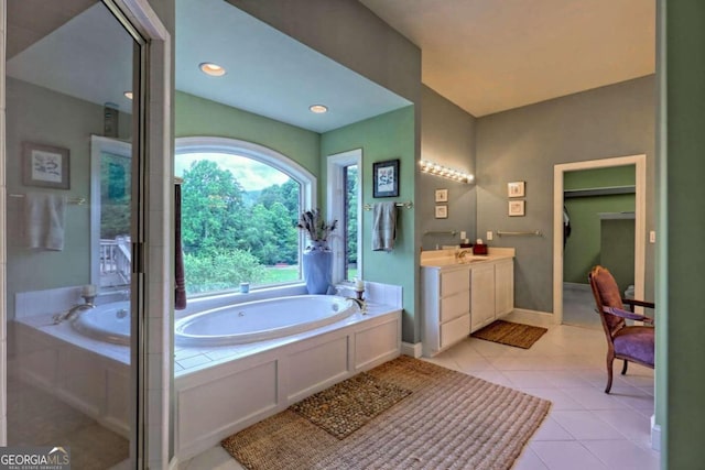 bathroom featuring vanity, tile patterned flooring, and a relaxing tiled tub