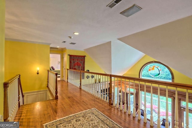 corridor with light hardwood / wood-style floors and vaulted ceiling