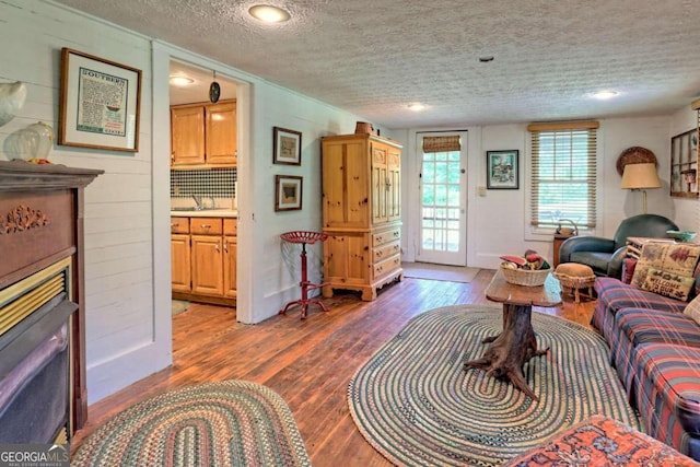 living room featuring dark wood-type flooring and a textured ceiling