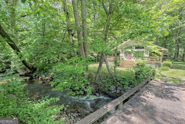 view of yard with a deck with water view