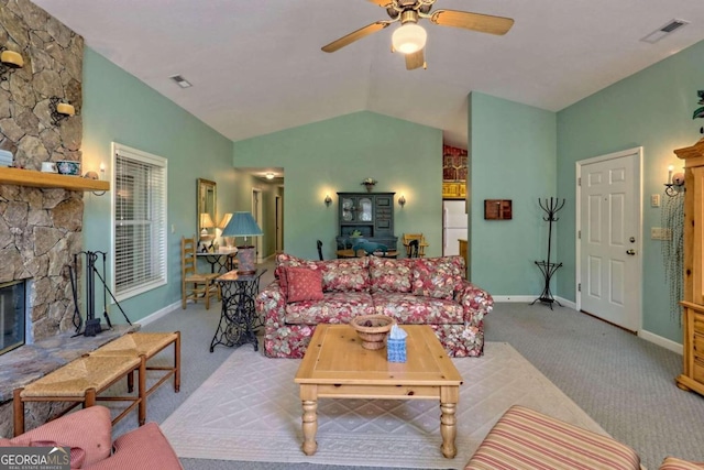 living room featuring a stone fireplace, light carpet, ceiling fan, and vaulted ceiling