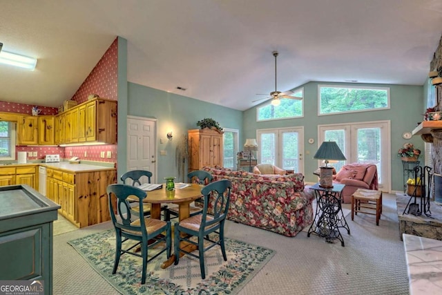 dining room featuring ceiling fan, light carpet, high vaulted ceiling, and french doors