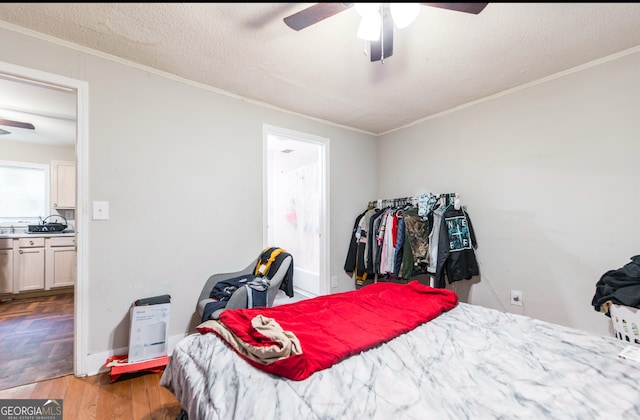 bedroom with wood-type flooring, a textured ceiling, ceiling fan, and crown molding