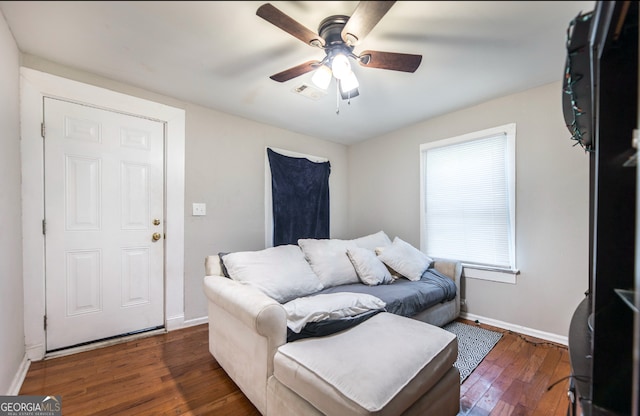 living room with ceiling fan and dark wood-type flooring