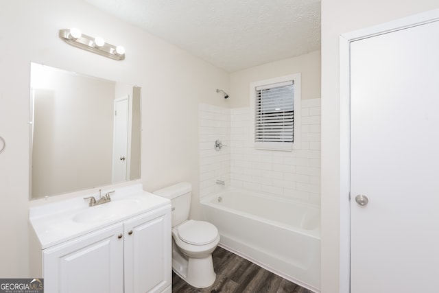 full bathroom featuring a textured ceiling, tiled shower / bath combo, vanity, toilet, and hardwood / wood-style flooring