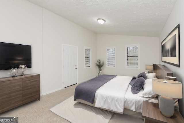 carpeted bedroom featuring a textured ceiling and vaulted ceiling