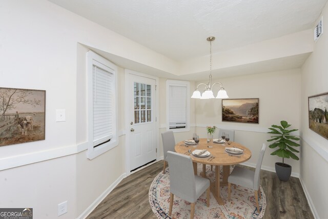 dining room featuring dark hardwood / wood-style flooring and an inviting chandelier