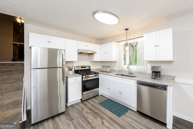 kitchen featuring stainless steel appliances, wood-type flooring, white cabinets, and sink