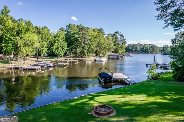 view of dock with a yard and a water view