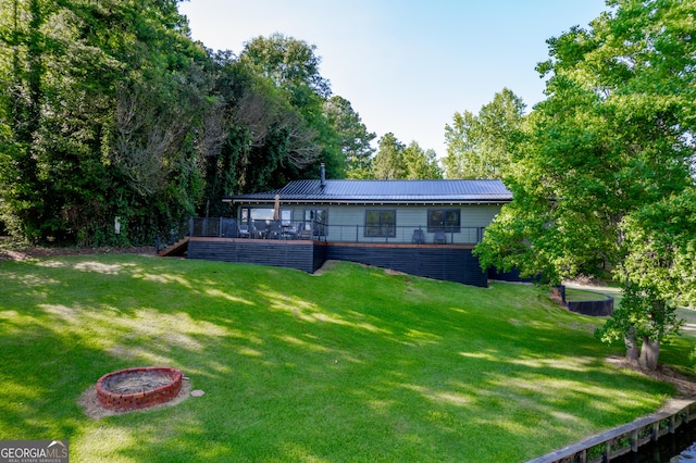 back of property featuring a wooden deck and a yard