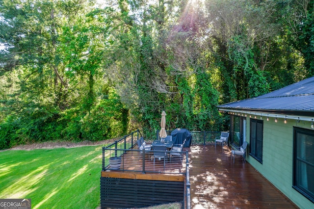 wooden deck with grilling area and a lawn