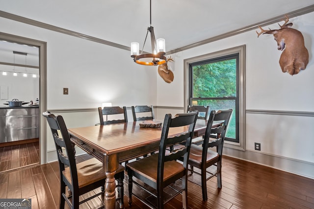 dining space featuring ornamental molding, dark wood-type flooring, and a notable chandelier