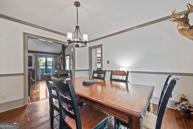 dining area with a chandelier, hardwood / wood-style floors, and crown molding