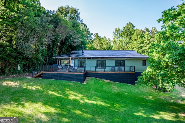 rear view of property with a lawn and a deck