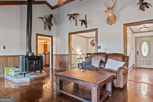 living room with wood-type flooring, a wood stove, and ornamental molding