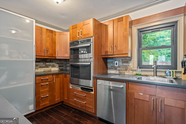 kitchen featuring decorative backsplash, sink, stainless steel appliances, and ornamental molding