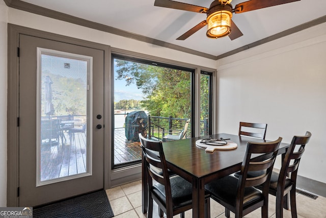 tiled dining area featuring ceiling fan, a healthy amount of sunlight, and ornamental molding