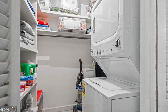 clothes washing area with stacked washer / dryer