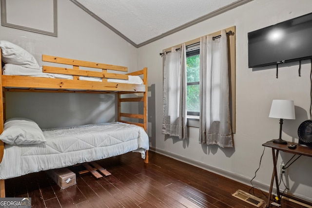 bedroom with crown molding, lofted ceiling, and hardwood / wood-style flooring