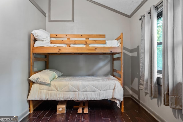 bedroom featuring ornamental molding, vaulted ceiling, and hardwood / wood-style flooring