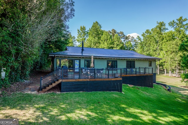 rear view of property with a yard and a wooden deck