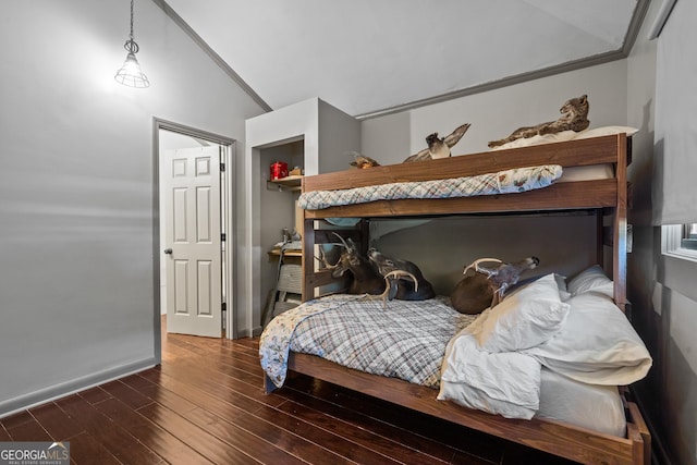 bedroom featuring dark hardwood / wood-style floors, lofted ceiling, and crown molding