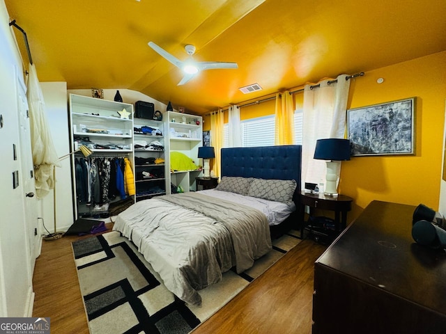 bedroom with wood-type flooring, ceiling fan, and vaulted ceiling