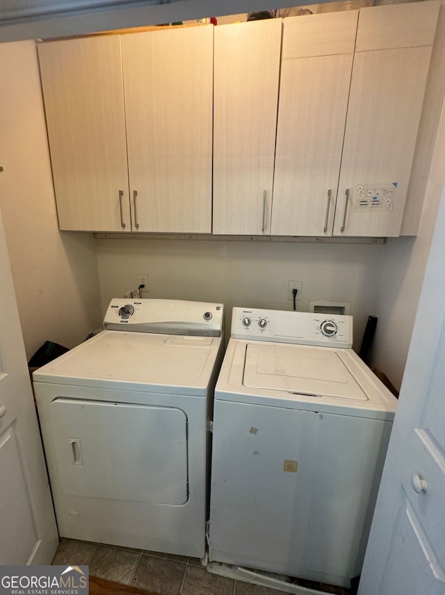 clothes washing area featuring cabinets, tile patterned floors, and washer and dryer