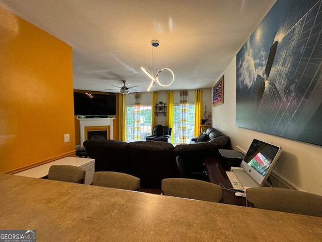 living room featuring ceiling fan with notable chandelier