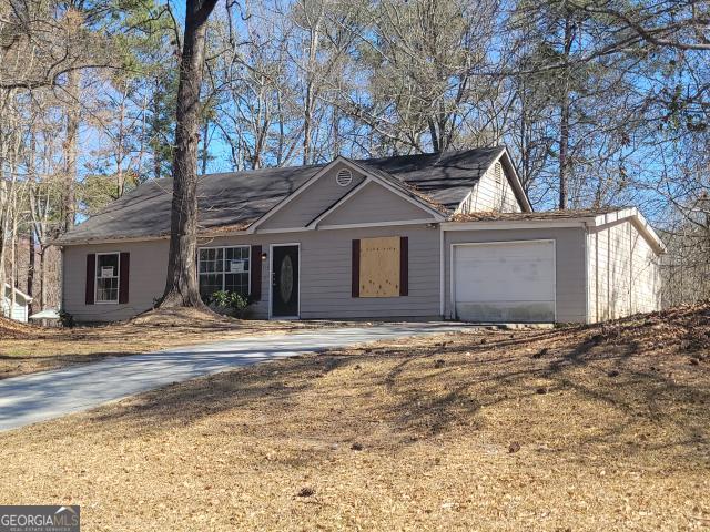 ranch-style house featuring a garage and driveway