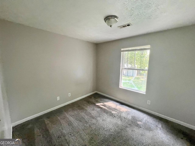 empty room featuring carpet flooring and a textured ceiling