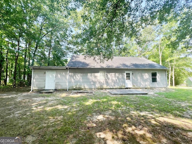 back of property featuring a patio area and a lawn