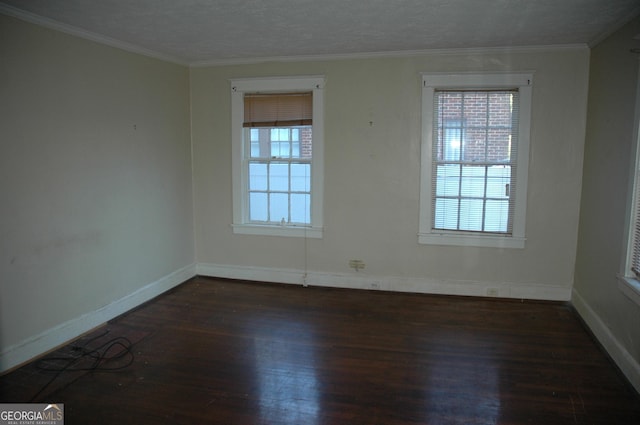 empty room featuring a textured ceiling, crown molding, plenty of natural light, and dark hardwood / wood-style floors