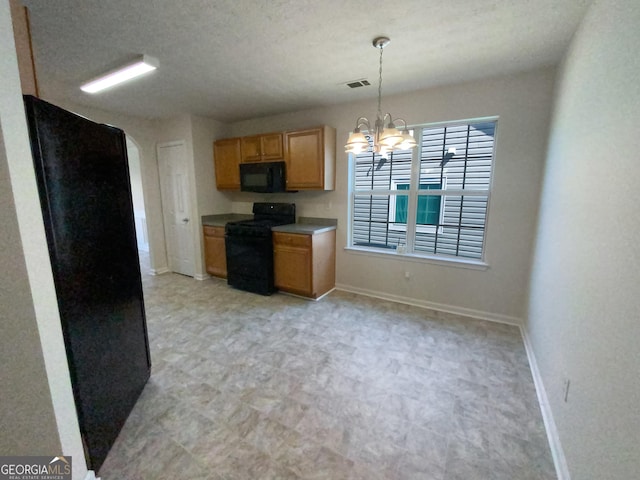 kitchen with a textured ceiling, black appliances, decorative light fixtures, and an inviting chandelier