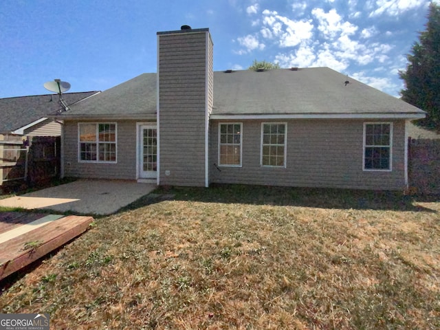 rear view of house with a lawn and a patio