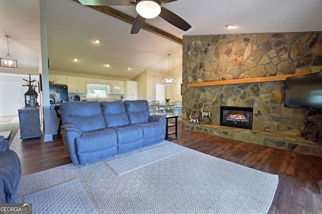 living room with ceiling fan, sink, vaulted ceiling with beams, a stone fireplace, and dark hardwood / wood-style flooring