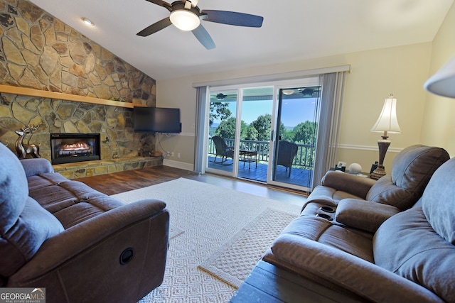 living room featuring hardwood / wood-style floors, ceiling fan, lofted ceiling, and a fireplace