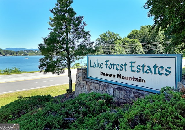 community sign featuring a water and mountain view