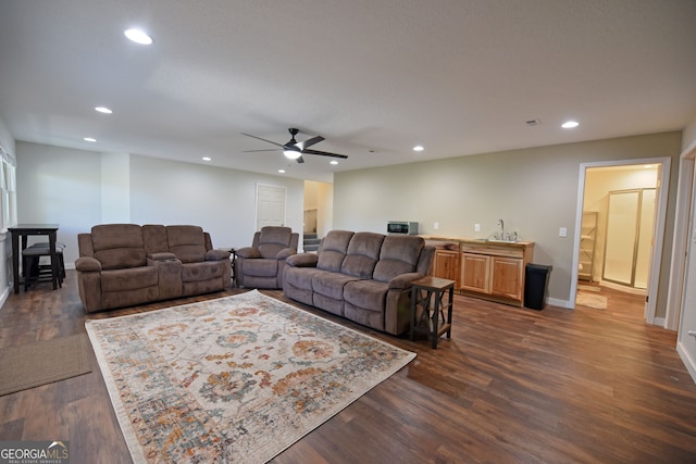 living room with ceiling fan, dark hardwood / wood-style flooring, and sink